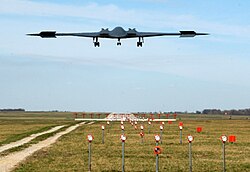後方から見た着陸態勢の B-2 スピリット ステルス爆撃機。両翼端のドラッグ・ラダー（スプリット・ラダー）が開いている