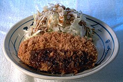コロッケとキャベツの千切りにソースをかけた調理の一例