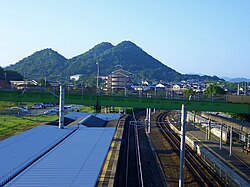 前掲写真の反対側、飯塚駅から望んだ飯塚市忠隈のボタ山。木々が生い茂っている(2007年)