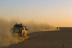 車の後ろに立ち上る風塵(砂塵)、スーダンの砂漠にて