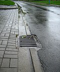 アスファルト舗装車道の縁にあるコンクリート製L形側溝と溝蓋