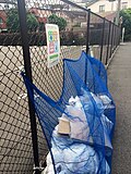 立入を防ぐために設置されたネットと、ゴミ袋にかぶせられた防鳥ネット
