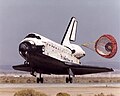 着地後にドラッグシュートを展開するスペースシャトル・ディスカバリー。垂直尾翼後縁の空力ブレーキも展開している。