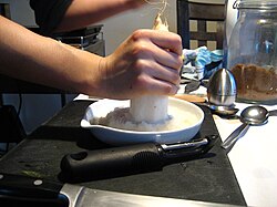 おろし器により大根をすり下ろす