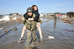 東日本大震災被災地で被災者を背負って移動する自衛官