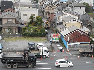 電気通信工事のために道路の通行止めを行っている様子。
